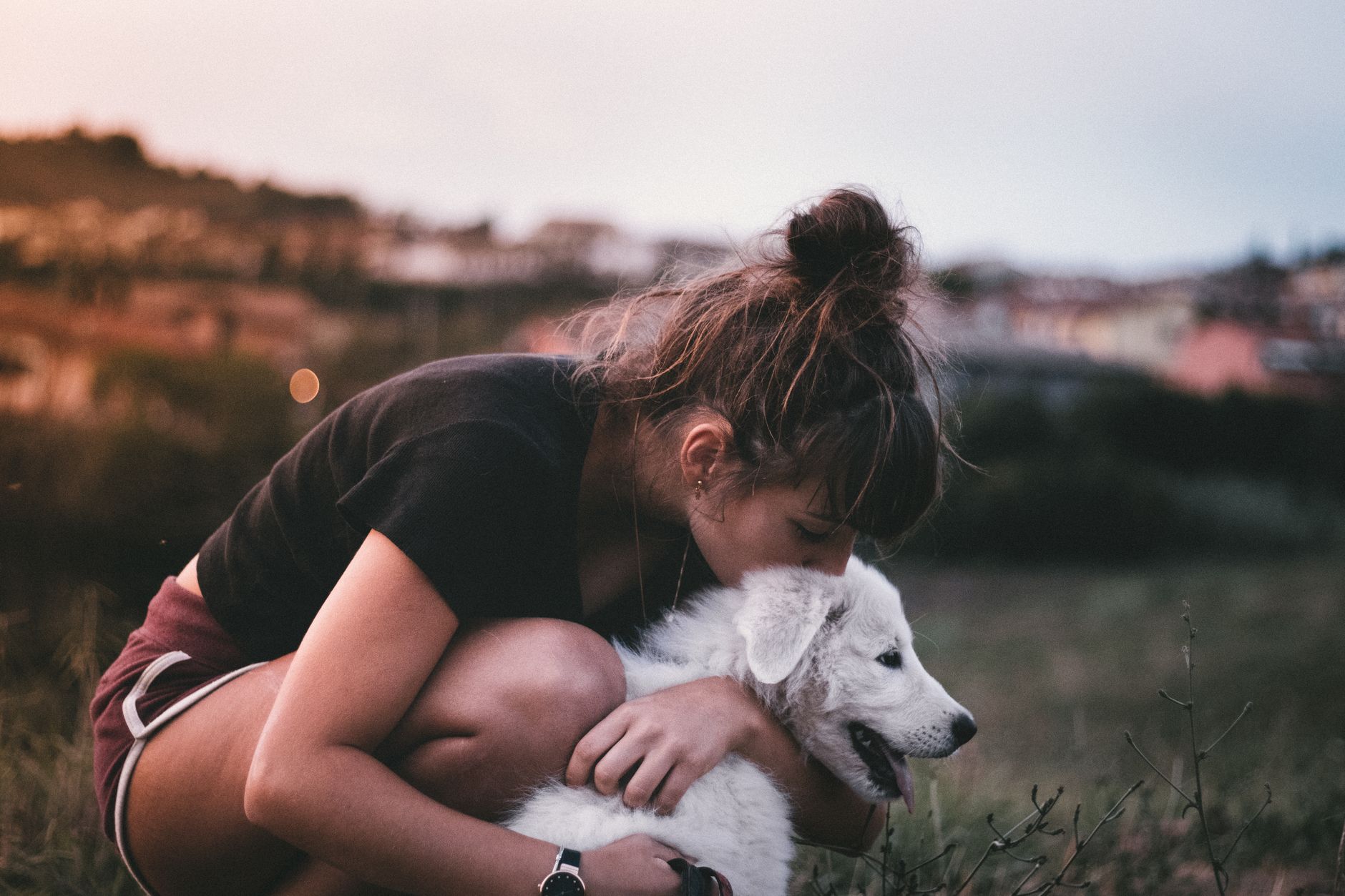 A Las Vegas pet owner holding her smiling dog in golden evening light